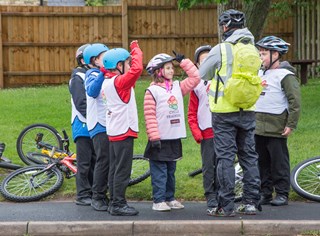 Children learning to ride their bikes safely on the road